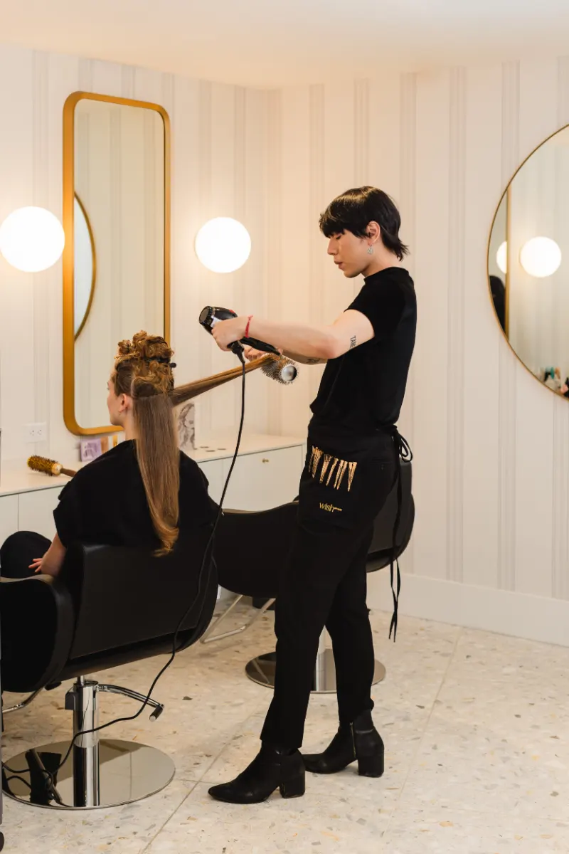 Stylist blow-drying a client with a round brush at Wish Dry Bar in downtown Vancouver