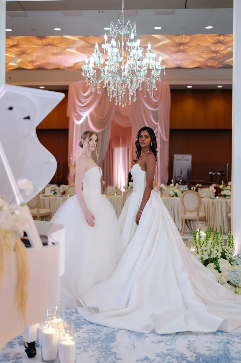 Two brides with a polished updo and long waves styled by Wish Dry Bar