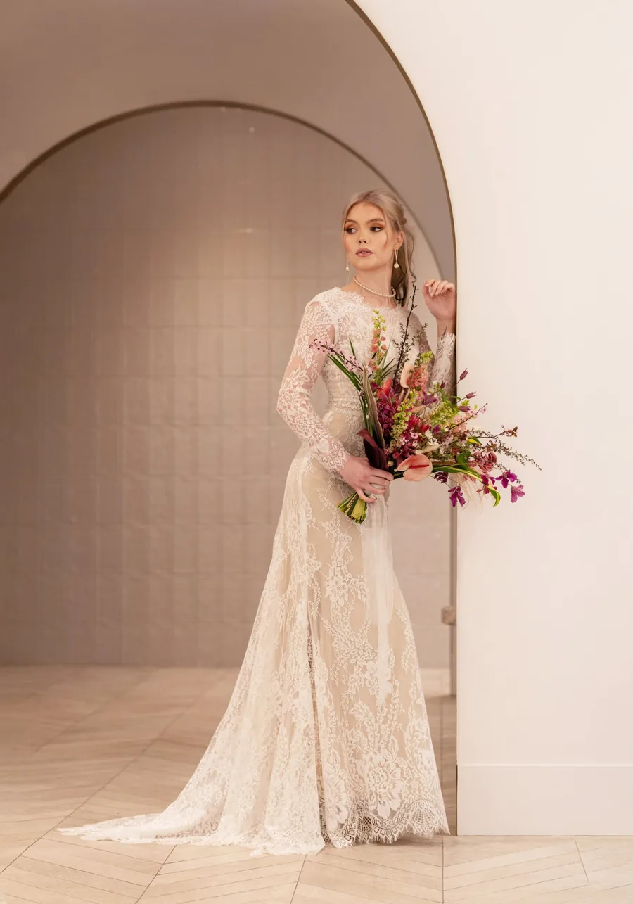 Bride with a soft bridal updo holding her bouquet before a Vancouver wedding