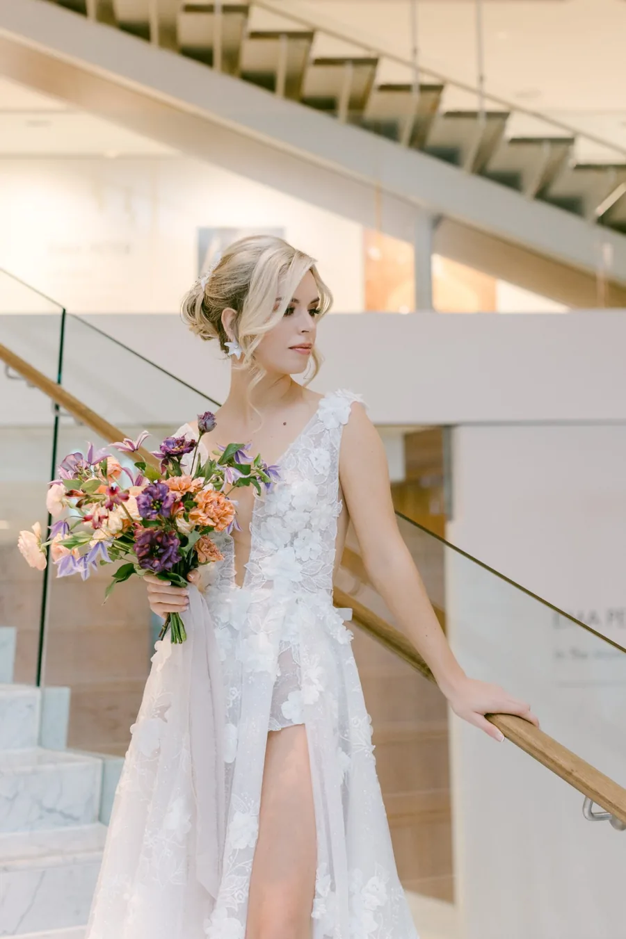 Bride with a low bridal updo on the staircase at her Vancouver venue