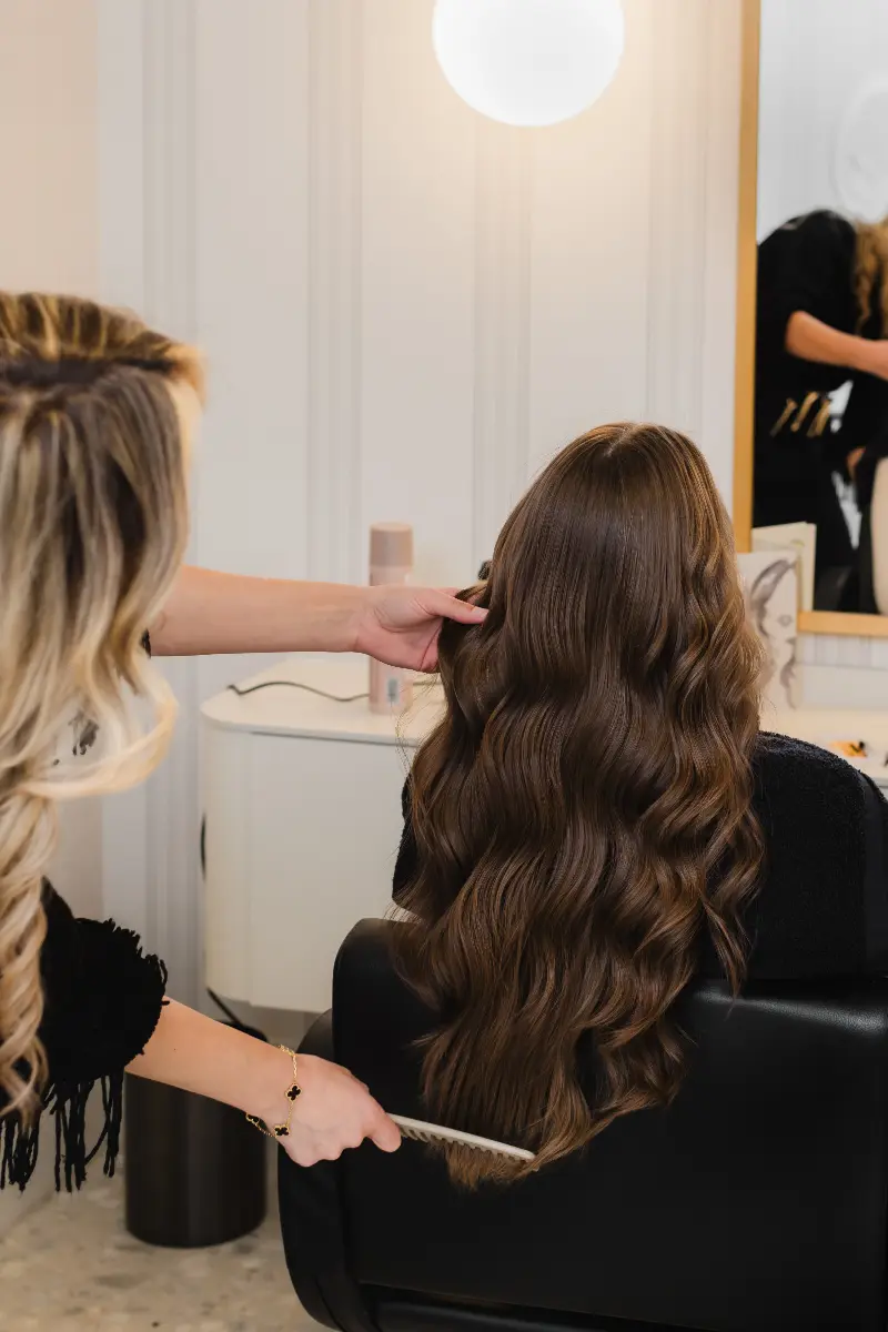 Stylist checking the length of a finished haircut at Wish Dry Bar
