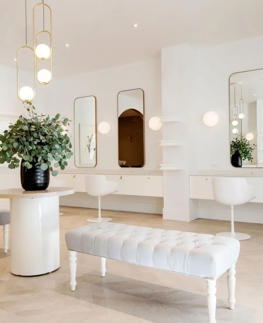 Wish Dry Bar West Vancouver salon interior with white tufted bench and gold chandeliers