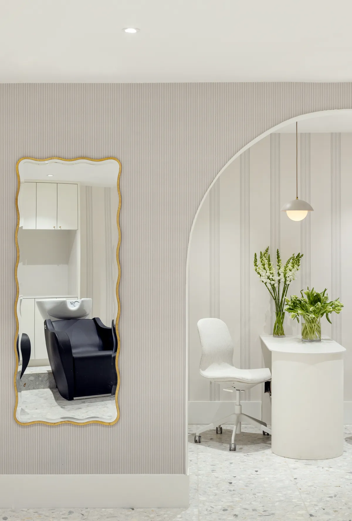 Wavy gold mirror and archway inside Wish Dry Bar in downtown Vancouver
